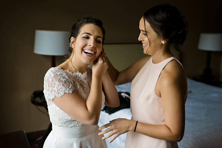 The maid of honor helps the bride put on her ear rings before the ceremony in Philly.